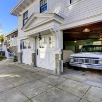 exterior of house with garage door open and car in storage