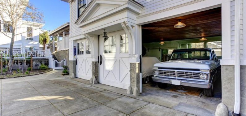 exterior of house with garage door open and car in storage